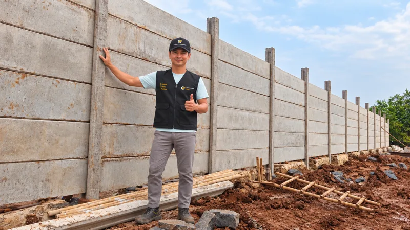 Petugas Cakra Prima Panel di depan pagar panel beton