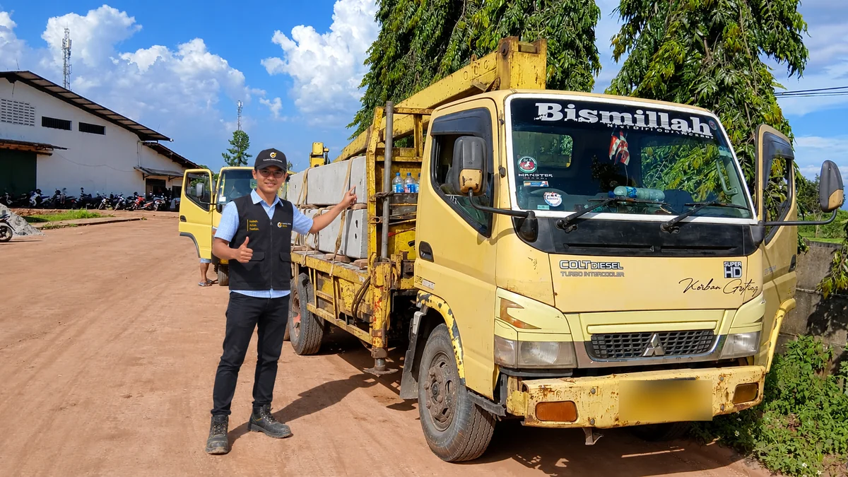 Petugas di depan truk pengangkut panel beton
